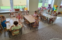 Dzieci jedza hot-dogi. Przekaska z okazji Dnia Dziecka.