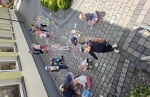 Dzieci maluja kreda na chodniku.