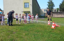 Dzieci leja woda z weza strazackiego