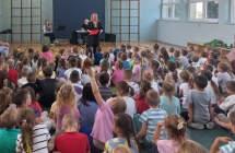 Przedszkolaki sluchaja prowadzacej audycje.