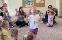 Dziewczynka bawi sie , wykonuje zadanie ruchowa, pokazuje jak lata motyl.