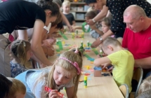 Dzieci wspolnie z roddzicami wykonuja wiannki dla Pani Lato