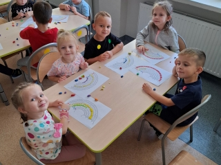 Dzieci z grupy Wiewiorki wykonuja kropkowa tecze wykorzytsujac plasteline.