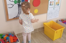 dziewczynka przykleja kropki na drzewie