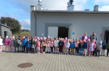 Zdjecie grupowe z przewodnikami na tle budynku w oczyszczalni.