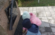 1. Dzieci ustawiaja znicz pod pomnikiem.