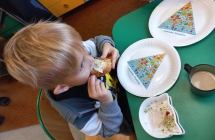 Chlopiec zjada  kanapke z kielkami.