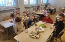 Dzien Zdrowego Sniadania- dzieci 5 letnie z grupy VII siedza przy stolikach.