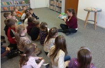 Dzieci sluchaja bajki czytanej przez p. bibliotekarke.