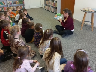 Dzieci sluchaja bajki czytanej przez p. bibliotekarke.