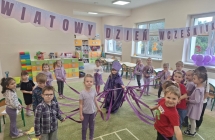 Dzieci tancza z fioletowymi wstazkami