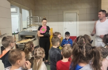 Dzieci z grupy VII wreczja podziekowanie pracownikom piekarni