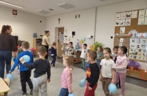 Dzieci z grupy VII bawia sie, trzymaja niebieskie balony, spiewaja i tancza.