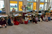 Pielegniarka pokazuje dzieciom ilustracje wirusow i bakterii.