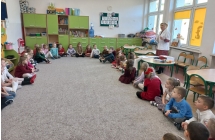 Pielegniarka opowiada dzieciom o piramidzie zywienia.