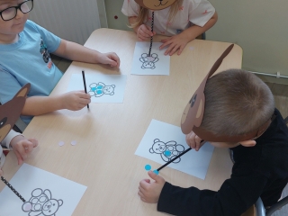 3. Dzieci ozdabiaja misie przy pomocy slomek.