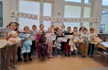 Dzien Pluszowego Misia w grupie dzieci piecioletnich. Dzieci stoja zew swoimi misiami, prezentuja otrzymane dyplomy.