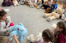 Dzieci z grupy Wiewioreczki podczas Dnia Pluszowego Misia siedza na dywanie i prezentuja swoje misie.