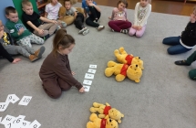 Dziewczynka ukada zapis dzialania mtematycznego dot. liczby misiow.