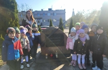 Dzieci z grupy VII zapalaja znicz pod pomnikiem Walczacym o Wolnosc Ojczyzny z okazji obchodow Swieta Niepodleglosci