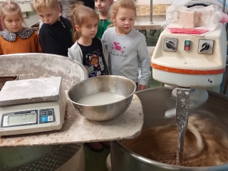 Dzieci przy maszynie wyrabiajacej ciasto