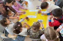 Dzieci wspolnie ozdabiaja plakat.