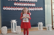 dziewczynka stoi z dyplomem