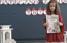 dziewczynka w stroju goralskim trzyma dyplom