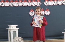 dziewczynka z grupy IX stoi z dyplomem