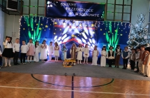 Dzieci w swiatecznej aranzacji spiewaja kolede.