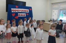 1. Dziewczynka z chlopcem mowia wierszyk. W tle inne dzieci.