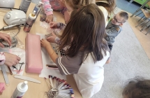 Dziewczynki ogladaja ozdoby do stylizacji paznokci.