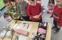 Chlopcy i dziewczynki z grupy Wiewioreczki ogladaja narzedzia niezbedne do stylizacji paznokci.