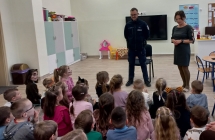 Pani dyrektor przedstawia dzieciom policjanta.