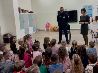 Pani dyrektor przedstawia dzieciom policjanta.