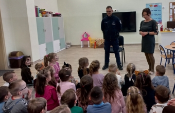 Pani dyrektor przedstawia dzieciom policjanta.