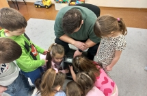 Pan informatyk opisuje dzieciom wyposazenie swojej torby z narzedziami. 