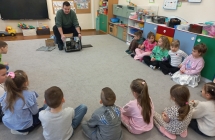 Pan informatyk demonstruje dzieciom  budowe komputera.