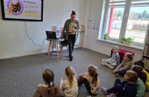 Dzieci z grupy VII siedza na dywanie i sluchaja ciekawostek o Janie Brzechwie