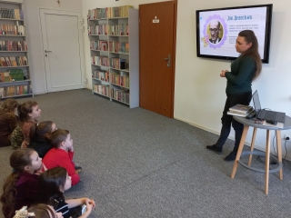 Pani bibliotekarka przybliza dzieciom postac poety.