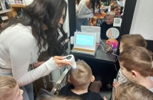 Pani bada dzieciom wlosy trychoskopem.