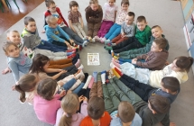 Dzieci z gr. IX siedza w kole i prezentuja swoje kolorowe skarpetki.
