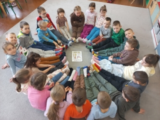 Dzieci z gr. IX siedza w kole i prezentuja swoje kolorowe skarpetki.