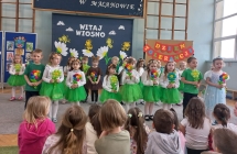 Dzieci z gr. VI podczas spiewu z kolorowymi kwiatami.