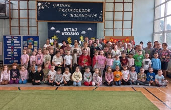 Zdjecie grupowe na tle dekoracji.