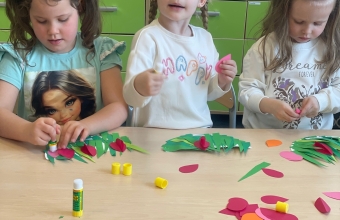 Dzieci przyklejaja kwiatki