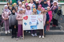 Szesciolatki z gr.VIII i IX przed budynkiem przedszkola z transparentem.