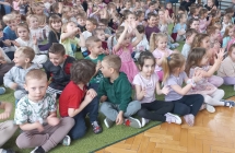 Wesole dzieci klaszcza do rytmu podczas audycji muzycznej.