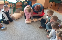 Dziewczynka wykonuje resustytacje na fantomie.