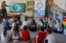 Dzieci ogladaja slajdy na tablicy ineraktywnej.